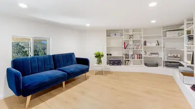 a blue couch in a living room with white shelves at Designer Retreat w Pool Firepits Panoramic Views The Lake House at Malibu in Agoura Hills
