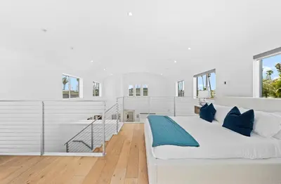 a white bedroom with a large bed with blue pillows at The Diamond Dune Three floors Two Balconies BBQ in Los Angeles