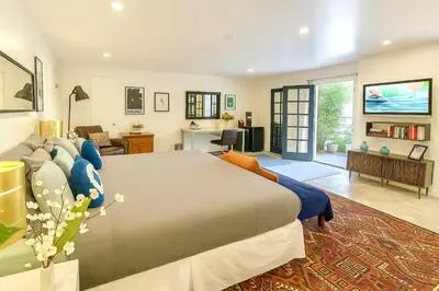 a bedroom with a large bed and a living room at Hollywood Hills Spa Retreat Oasis with Tree Top Views, Private Jacuzzi Style Tub, Steam Room, Magical Half Acre Acre Garden and Patio, Free Parking for 2 cars, in LA's most Serene, Central Desirable Area in Los Angeles