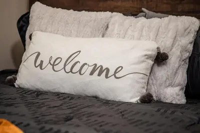 a pillow with welcome written on it on a bed at NEW and Modern Cozy Flat in Southern California in Covina