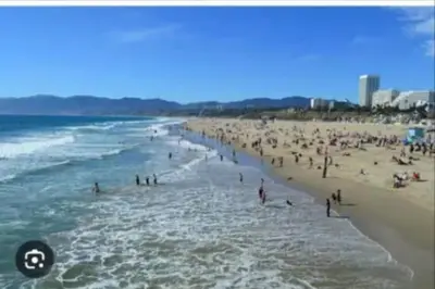 a large group of people on a beach at Walk to Santa Monica Beach Pier Boardwalk Venice in Los Angeles