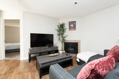 a living room with a couch and a flat screen tv at 2BR Hollywood Apt with Rooftop Pool & Stunning Views in Los Angeles