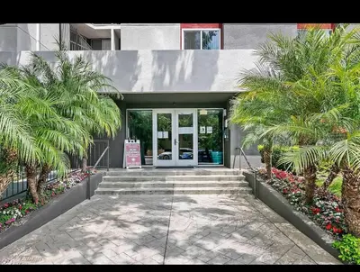 a building with palm trees in front of a door at Modern Escape in Hollywood with Rooftop & City Views in Los Angeles