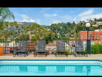 a group of chairs sitting next to a swimming pool at Modern Escape in Hollywood with Rooftop & City Views in Los Angeles