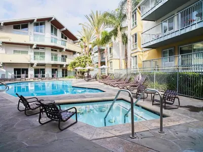 a swimming pool with chairs and a building at The Amethyst Retreat Ocean Marina Panoramic View in Los Angeles