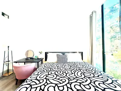 a bedroom with a black and white bed and a desk at LA Modern Street View Glass Window 2BR in North Sherman Way