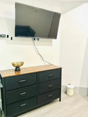 a tv on top of a dresser in a room at LA Modern Street View Glass Window 2BR in North Sherman Way
