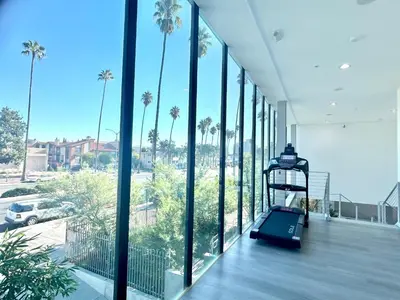 a room with a view of a building with palm trees at LA Modern Street View Glass Window 2BR in North Sherman Way