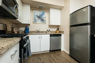a kitchen with white cabinets and a stainless steel refrigerator at Stunning 2 bedroom near by The Grove in Los Angeles