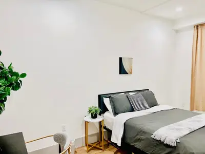a bedroom with a bed and a white wall at Modern New Studio Cozy&Prime Location in North Sherman Way