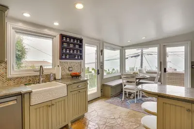 a kitchen with a sink and a table and windows at Walk to Private Beach Rancho Palos Verdes Escape! in Rancho Palos Verdes