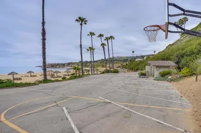 an empty basketball hoop on the beach with palm trees at Walk to Private Beach Rancho Palos Verdes Escape! in Rancho Palos Verdes