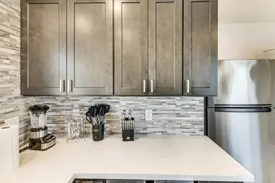 a kitchen counter with wooden cabinets and a refrigerator at 4 Mi to SoFi Stadium Pet-Friendly LA Area Home in Los Angeles