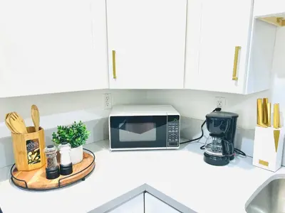 a kitchen counter with a microwave and a cutting board at Newly Built Modern Central 2B On Sherman with Free Parking in North Sherman Way