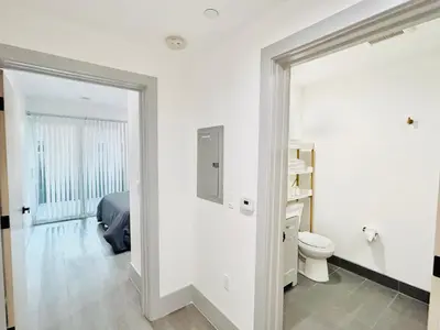 a white bathroom with a bed and a toilet at Newly Built Modern Central 2B On Sherman with Free Parking in North Sherman Way