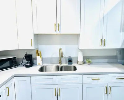 a kitchen with white cabinets and a sink at Newly Built Modern Central 2B On Sherman with Free Parking in North Sherman Way