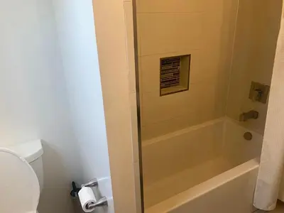 a bathroom with a shower with a tub and a toilet at Spanish Cottage on Rosewood Avenue, Los Angeles , Melrose Village in Los Angeles