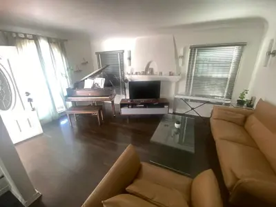 a living room with a couch and a piano at Spanish Cottage on Rosewood Avenue, Los Angeles , Melrose Village in Los Angeles