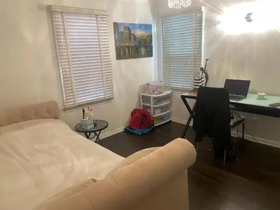 a bedroom with a bed and a desk with a laptop at Spanish Cottage on Rosewood Avenue, Los Angeles , Melrose Village in Los Angeles