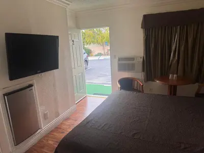 a bedroom with a bed and a flat screen tv at Haystack Motel in Long Beach