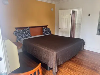 a bedroom with a large bed and a window at Haystack Motel in Long Beach
