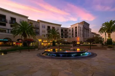 a building with a fountain in the middle of a courtyard at Premier Suites at Marina-Venice with Luxe Pool, Gym & Hot Tub & More in Los Angeles