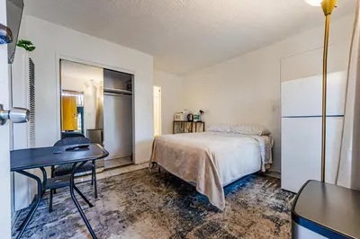 a bedroom with a bed and a desk and a table at Relaxing Studio 12 in Los Angeles