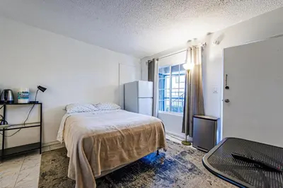 a bedroom with a bed and a refrigerator at Relaxing Studio 12 in Los Angeles