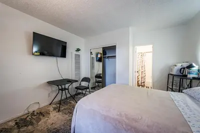 a bedroom with a bed and a table and a television at Relaxing Studio 12 in Los Angeles