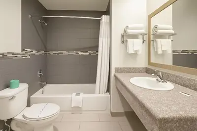 a bathroom with a toilet and a sink and a tub at Casa Blanca Hotel - Corona in Corona