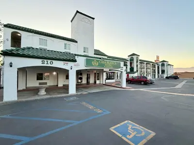 an empty parking lot in front of a building at Casa Blanca Hotel - Corona in Corona