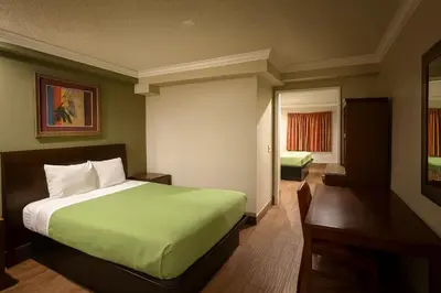 a hotel room with a bed and a window at Casa Blanca Hotel - Corona in Corona