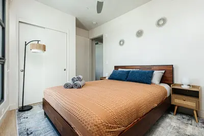 a bedroom with a large bed with blue pillows at Stunning 2BR apartment steps from Santa Monica pier in Los Angeles