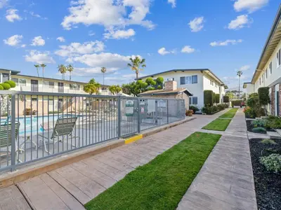 a walkway with a fence and a pool at Beautiful 2 Bed Beach Condo #104 in Carpinteria