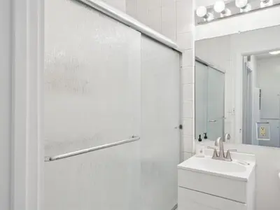 a white bathroom with a sink and a shower at Beautiful 2 Bed Beach Getaway #115 condo in Carpinteria