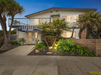 a house with palm trees in front of it at Beautiful 2 Bed Beach Getaway #115 condo in Carpinteria