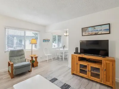 a living room with a flat screen tv and a chair at Beautiful 2 Bed Beach Getaway #115 condo in Carpinteria
