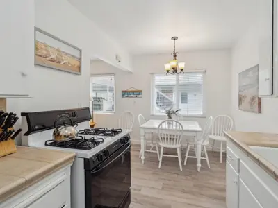 a kitchen with a stove and a table with chairs at Beautiful 2 Bed Beach Getaway #115 condo in Carpinteria
