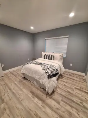 a bedroom with a bed in a room with wood floors at My amazing home in Azusa