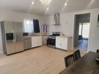 a kitchen with stainless steel appliances and a dining table at WG House Winnetka Los Angeles in Winnetka