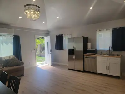 a kitchen with a stainless steel refrigerator and a couch at WG House Winnetka Los Angeles in Winnetka