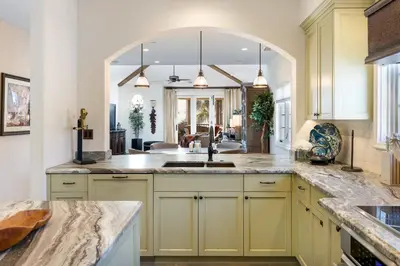 a kitchen with yellow cabinets and a large mirror at Seventh Shore Stylish Seal Beach Home w Elevator Fireplace Bold Design in Seal Beach