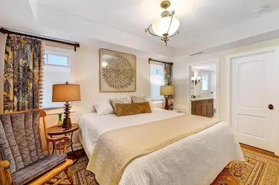 a bedroom with a bed and a chair at Seventh Shore Stylish Seal Beach Home w Elevator Fireplace Bold Design in Seal Beach