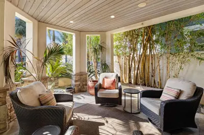a porch with chairs and tables and windows at Seventh Shore Stylish Seal Beach Home w Elevator Fireplace Bold Design in Seal Beach