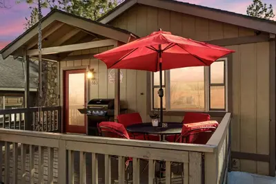 a patio with a table and chairs and an umbrella at Alpine Crest in Big Bear Lake in Big Bear Lake
