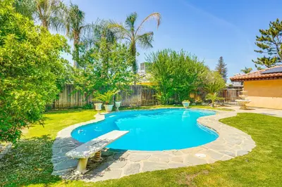 a swimming pool with a bench in a yard at 7 Mi to Dtwn Poolside Paradise in Bakersfield! in Bakersfield