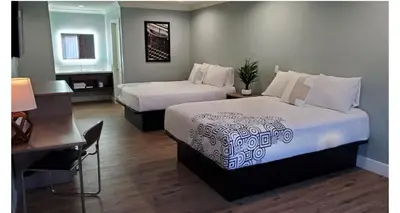 a hotel room with two beds and a desk at Crestridge Inn Near LAX, SoFi Stadium & Intuit Dome in Inglewood