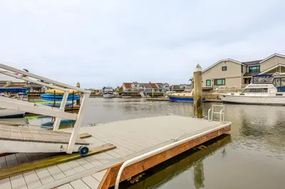 a dock with a boat in a body of water at Chic Coastal Home with Outdoor Oasis in Oxnard! in Oxnard