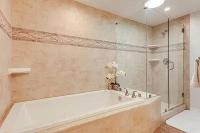 a bathroom with a tub and a glass shower at Chic Coastal Home with Outdoor Oasis in Oxnard! in Oxnard