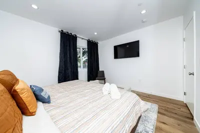 a bedroom with a bed and a tv on the wall at NoHo Home Near Universal Studios in Burbank